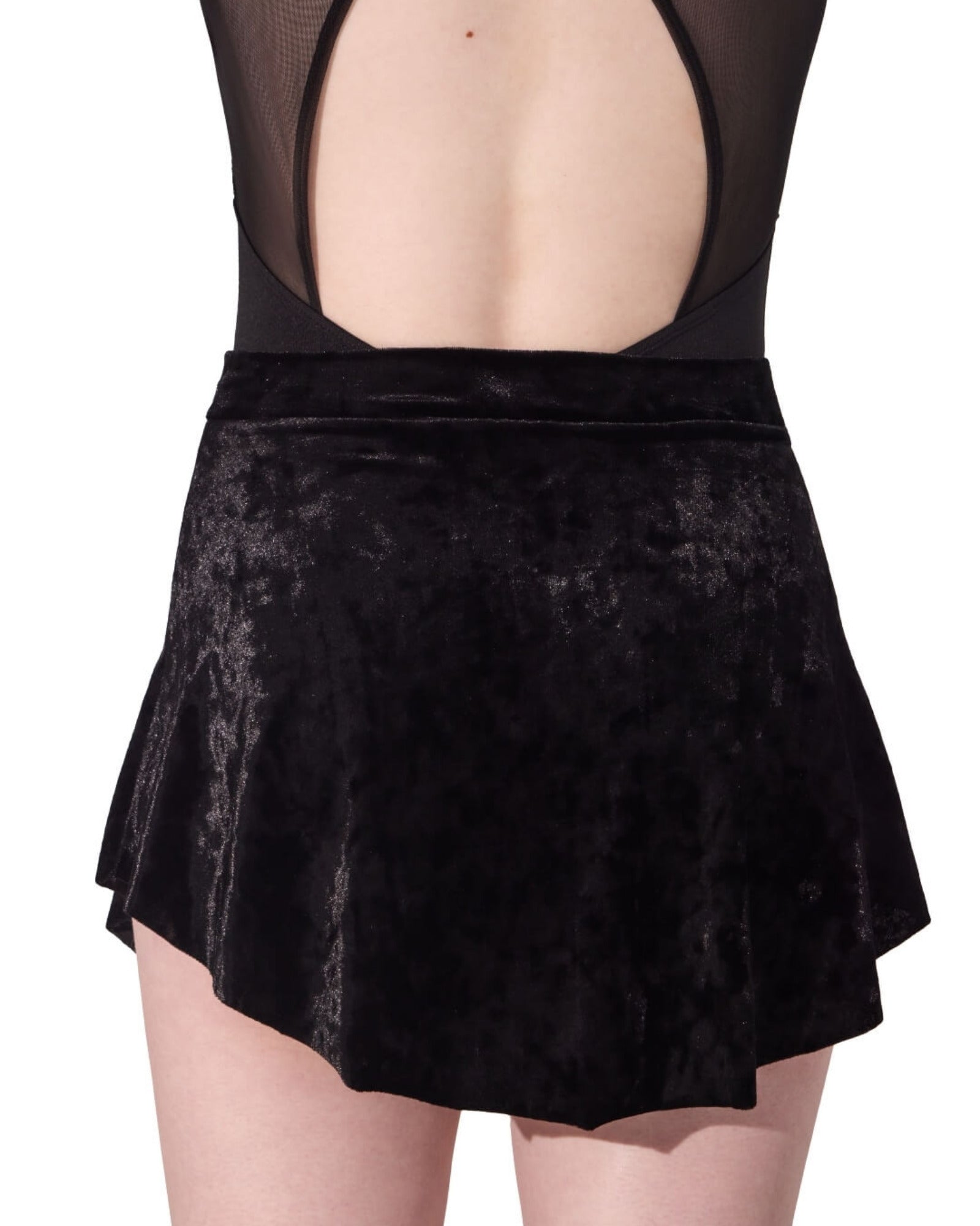 Black velvet skirt worn over a black mesh top on a white background