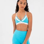 Woman wearing a blue crop top with a white accent on a light gray background.