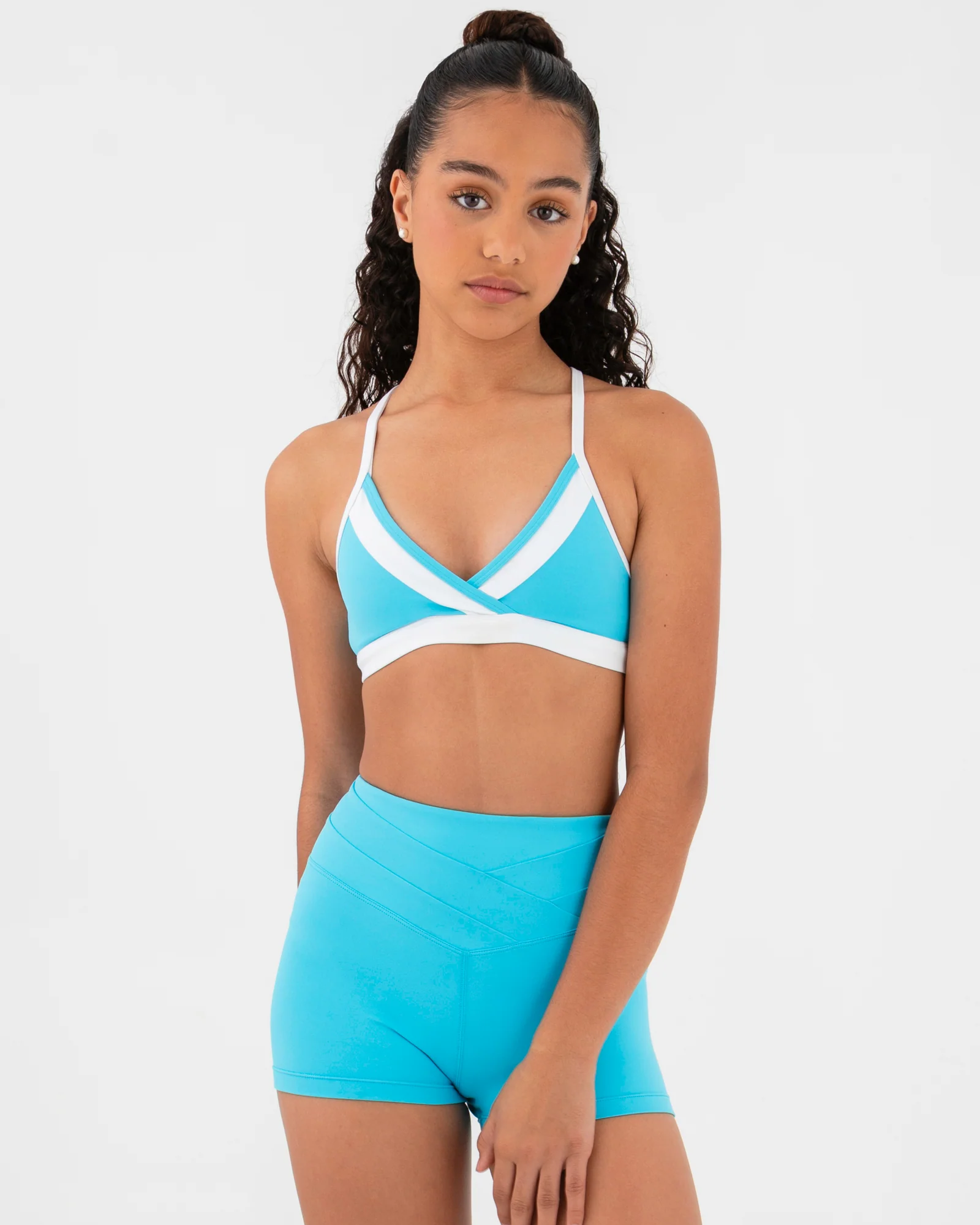 Woman wearing a blue crop top with a white accent on a light gray background.