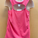 A bright pink sleeveless tank top displayed on a beige mannequin torso against a light wood background. The tank has a double-strap racerback design with a cutout at the upper back and a white inner collar trim.
