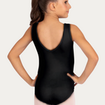 Young girl wearing a black leotard and pink tights on a white background