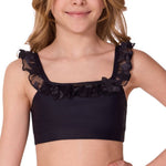 Young girl wearing a black crop top with ruffled details on a white background