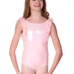 Young girl wearing a pink leotard with ruffled shoulders on a white background