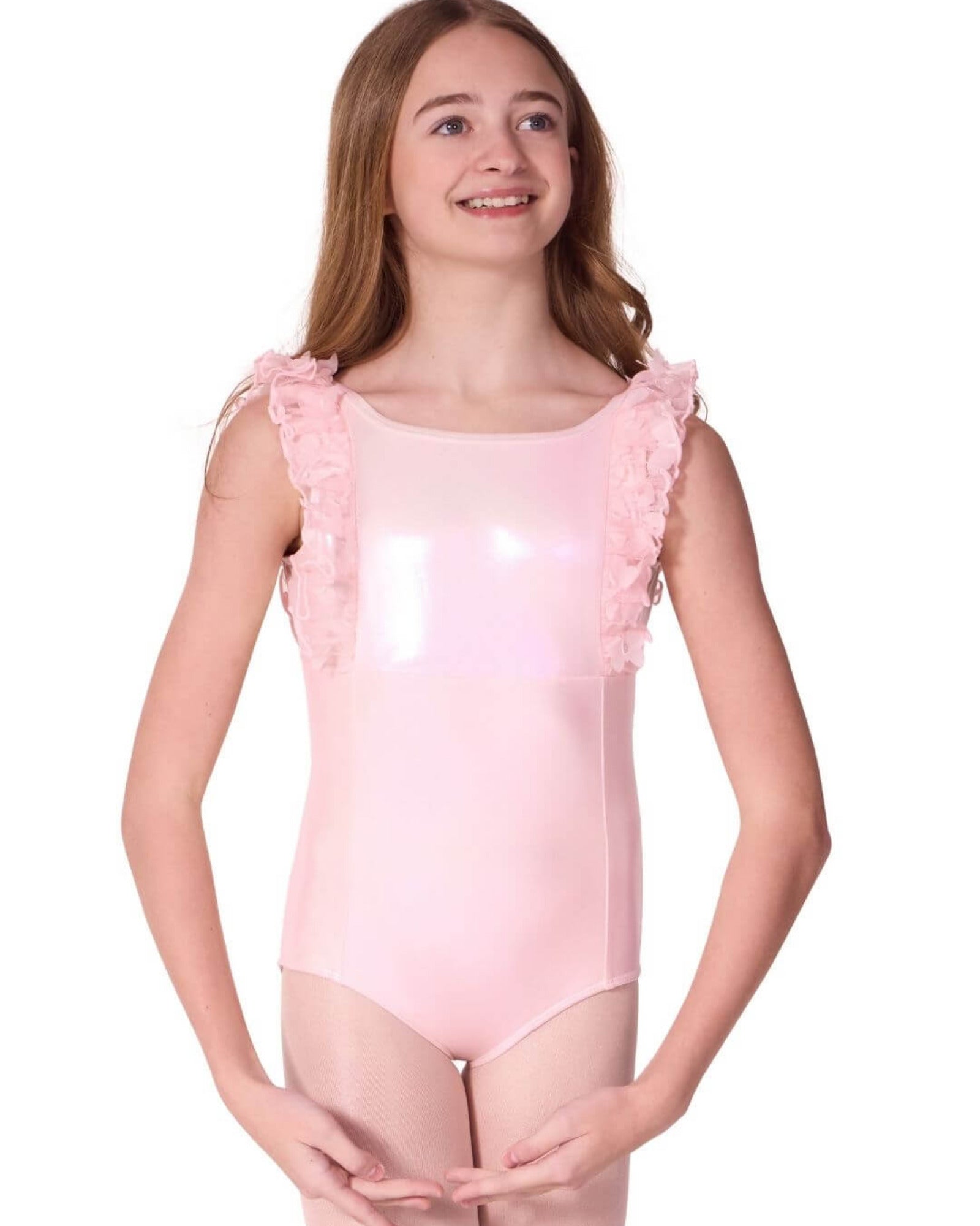 Young girl wearing a pink leotard with ruffled shoulders on a white background